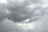 Dark storm clouds before rain. Use as texture, background. View from the window with raindrops
