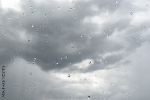 Dark storm clouds before rain. Use as texture, background. View from the window with raindrops