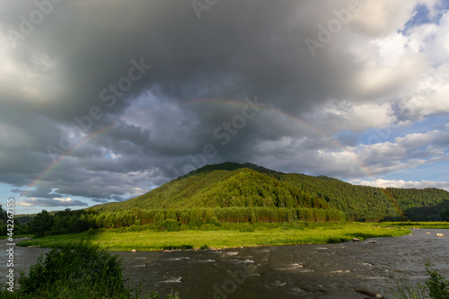 bright rainbow in the evening sky in the mountains