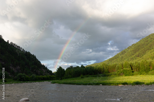 bright rainbow in the evening sky in the mountains