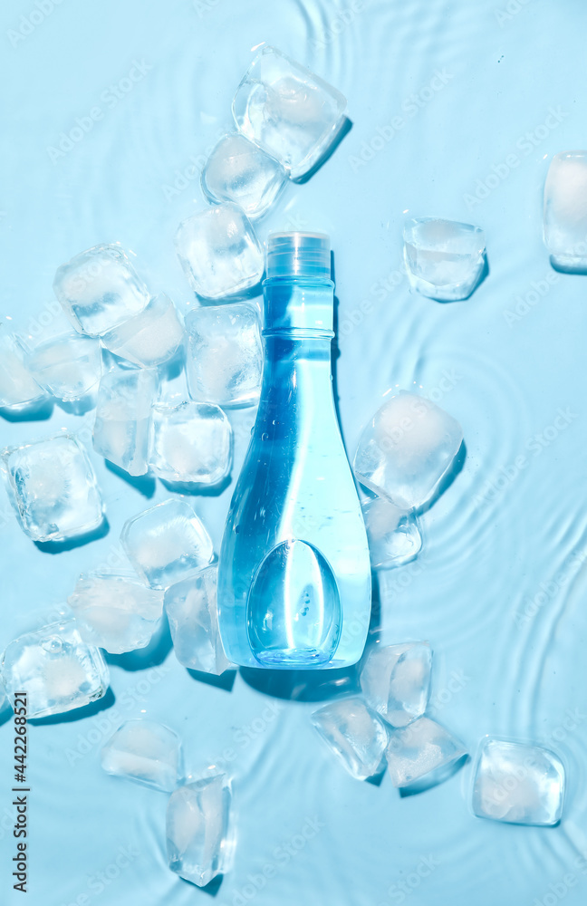 Bottle of cosmetic product and ice cubes in water on color background Bottle of cosmetic product and ice cubes in water on color background