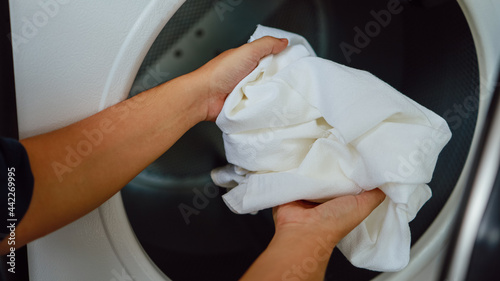 Man doing launder holding basket with dirty laundry of the washing machine in the public store. laundry clothes concept