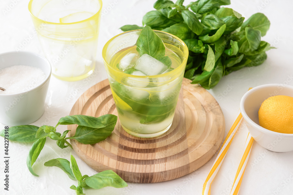 Glass of lemonade with basil on light background Glass of lemonade with basil on light background