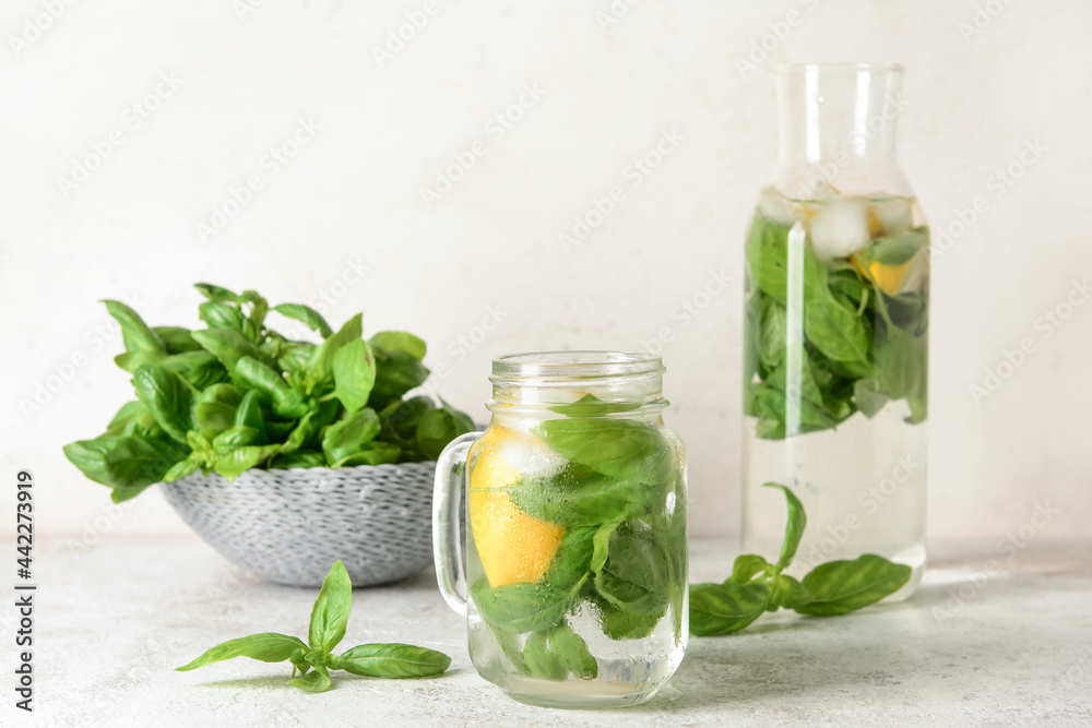 Mason jar of lemonade with basil on light background Mason jar of lemonade with basil on light background