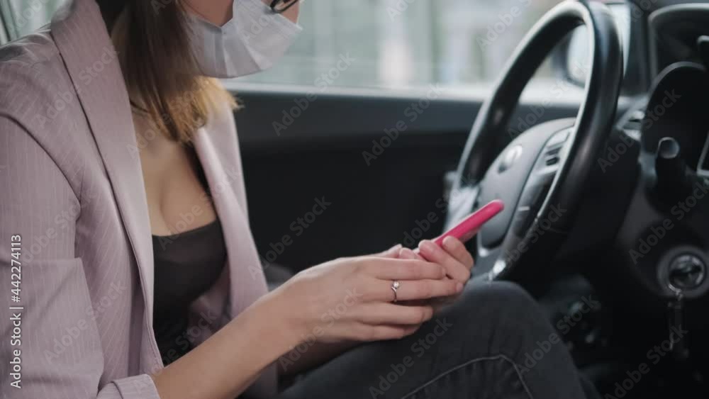 Female passenger in mask using phone in the car Female passenger in mask using phone in the car