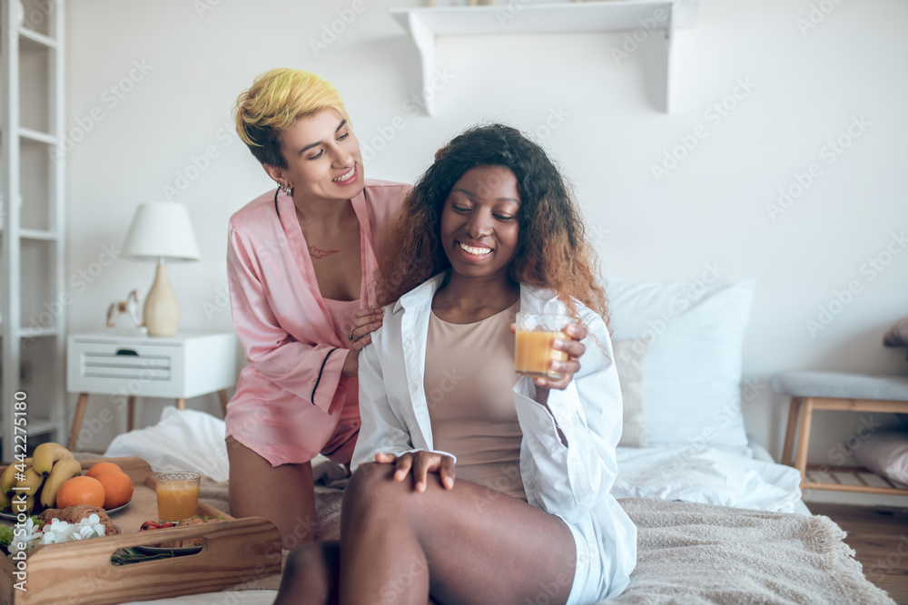 Two women communicating happy on bed Two women communicating happy on bed