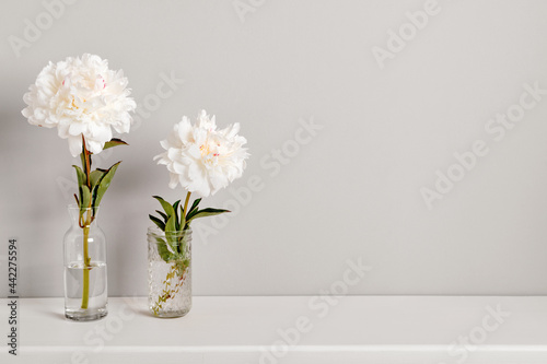 Romantic elegant peonies flowers arrangement on table wall background. Template for text or artwork