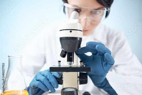 woman doctor laboratory looking through microscope research science
