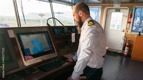 Navigational merchant officer watching keeping navigational watch on the bridge and watching ECDIS and radar.