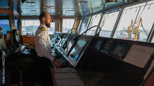 Navigational merchant officer watching keeping navigational watch on the bridge and watching ECDIS and radar photo