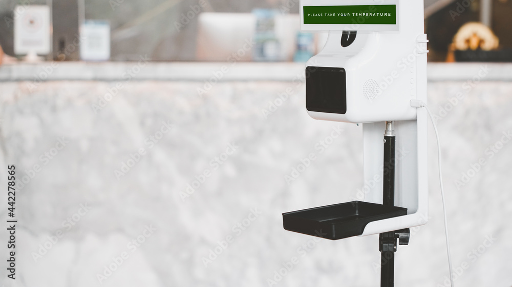 temperature digital scan machine with please take your temperature word on blurred reception counter background for screening customer to protection transmission of covid19