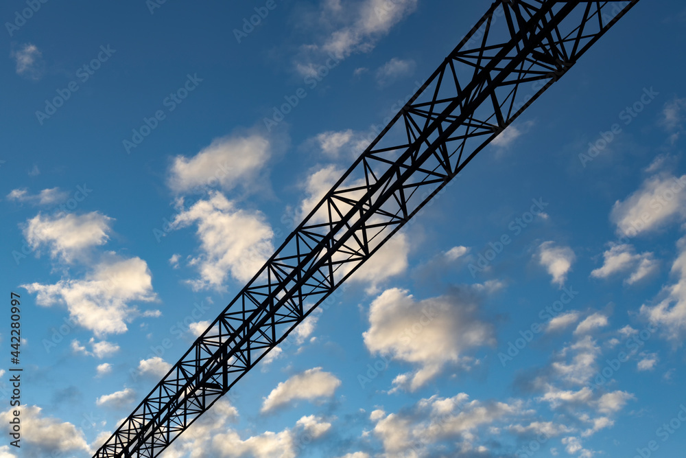 Metal beam at the top of the overall gate of the railway on a cloudy background