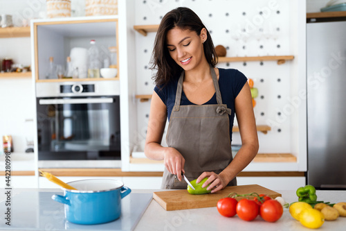 Young beautiful woman cooking healthy food in the kitchen. Healthy lifestyle, food, diet concept © NDABCREATIVITY
