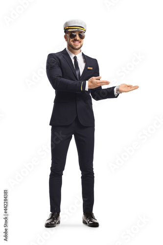 Full length portrait of a pilot in a uniform showing direction with hands © Ljupco Smokovski