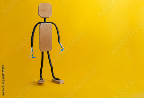 Wooden man on yellow background, copy space.