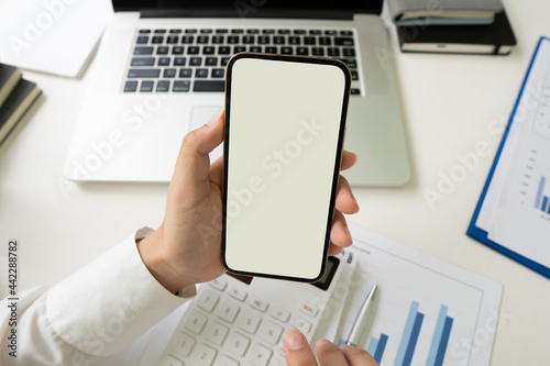 businessman hands using smartphone mockup at the white office desk. Blank screen mobile phone for graphic display montage,clipping path.