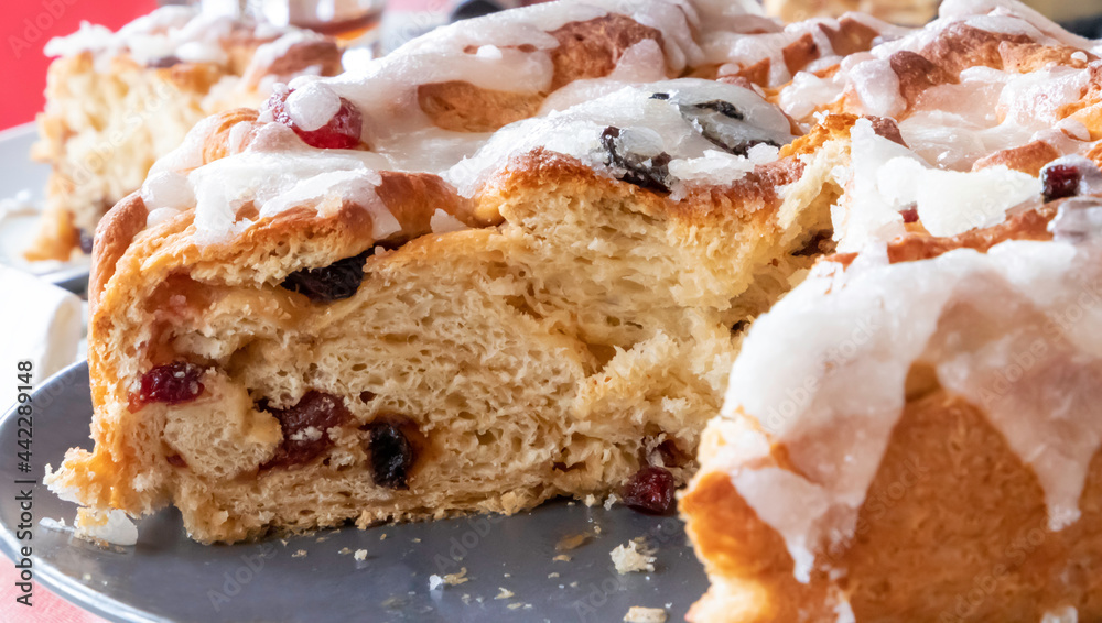 Close up of a freshly baked cake with red fruits and white sugar frosting - Chelsea bun Close up of a freshly baked cake with red fruits and white sugar frosting - Chelsea bun