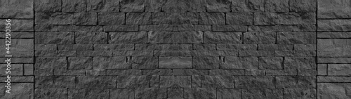 Black anthracite gray grey natural lava basalt stone wall texture, with wild bandage, privacy wall texture background banner panorama © Corri Seizinger