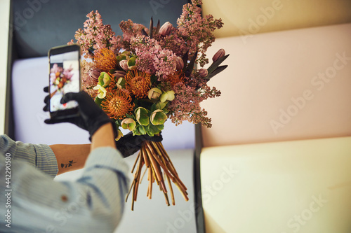Quadro su tela Female florist photographing a beautiful flower bouquet