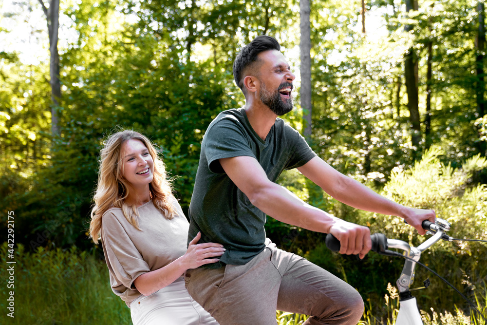 Happy couple having fun on a bike in nature Happy couple having fun on a bike in nature