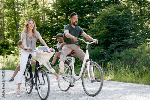 Fun family riding bicycles in the forest