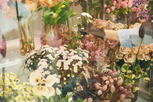 Professional florist selecting ornamental plants for a bouquet