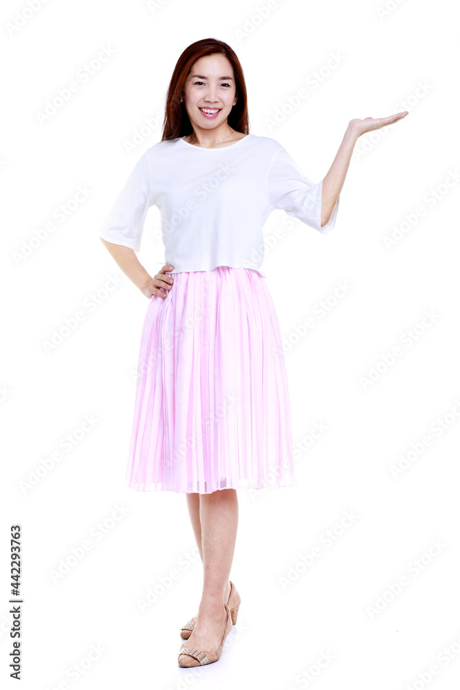 Full body of smiling young Asian female in white blouse and pink skirt pointing with hand aside isolated on white background Full body of smiling young Asian female in white blouse and pink skirt pointing with hand aside isolated on white background