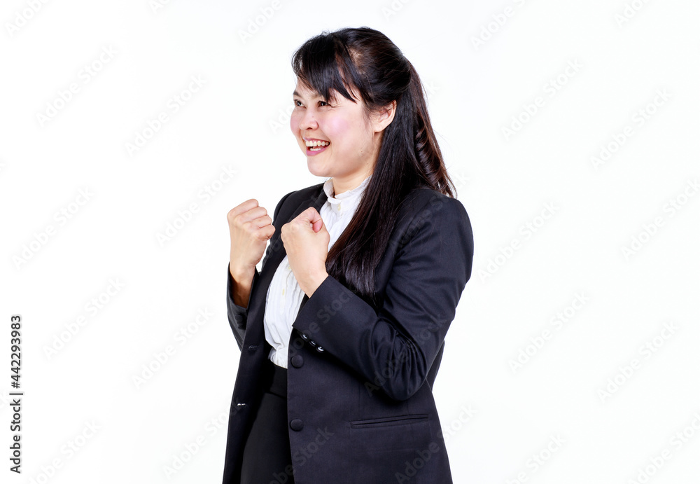 Young Asian female manager in formal black office outfit clenching fists and smiling happily while celebrating successful business deal against white background. Young Asian female manager in formal black office outfit clenching fists and smiling happily while celebrating successful business deal against white background.