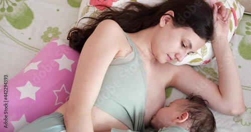 Mother breastfeeding her newborn baby on sofa. Milk from mother's breast is a natural medicine to baby. family, food, child, eating and parenthood concept