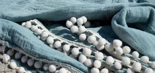 Muslin towel with braid with pompoms. Home textiles for the body made from organic cotton.