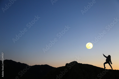mountain woman silohuette and moon in the sky