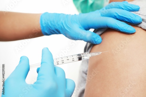 Female doctor injecting COVID-19 vaccine on female patient s shoulder flu vaccine corona virus treatment