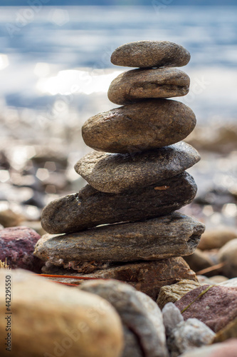Stone stacking, stones swaying in balance on beach. Close up.