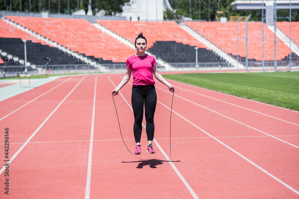 Attractive woman jumping rope at stadium