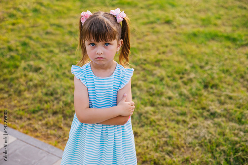 here is a little girl standing in a public park. The child is offended and upset. © Cherkasova Alie