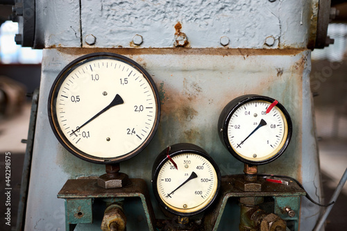 Retro style equipment of chemical plant three pressure gauges or manometers shows zero closeup with out of focus abstract industrial background with copyspace. photo