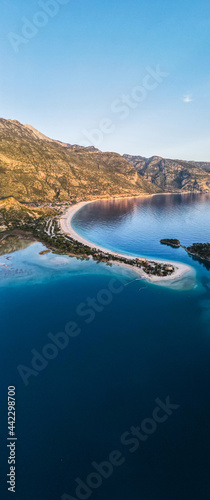An aerial view of the mountains, sea, green forest and turquoise blue water
