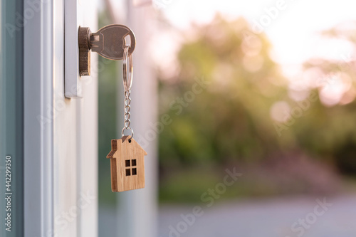 The house key is inserted in front of the door and opens to welcome the new owner. Home selling ideas, home mortgage photo