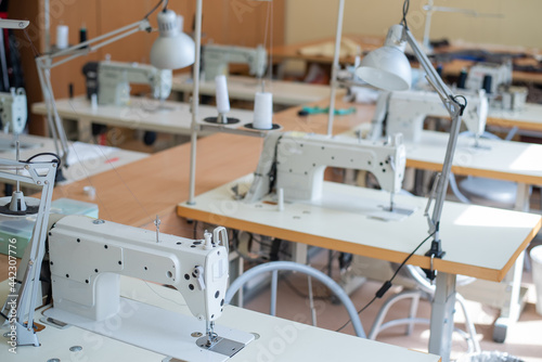 Working environment sewing workshop. Tailoring industry. Empty workplaces of seamstresses