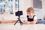 Boy At Home Wearing School Uniform Making Video Call On Mobile Phone