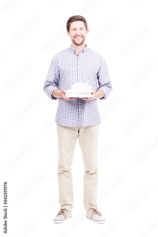 Studio portrait shot of handsome bearded Caucasian man wearing casual clothes holding house model in hands, white background Studio portrait shot of handsome bearded Caucasian man wearing casual clothes holding house model in hands, white background