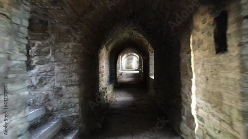 Moving in stone tunnel in medieval castle ruins