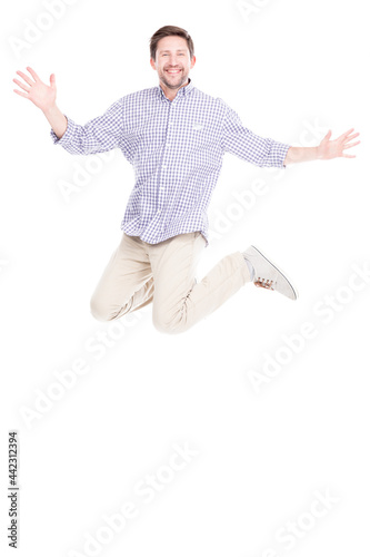 Vertical full length studio shot of joyful Caucasian man with beard on face wearing casual outfit jumping, white background