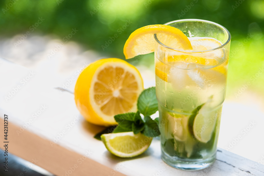 Cool freshly made lemonade and fruits. Lemon, lime and mint lemonade with ice.