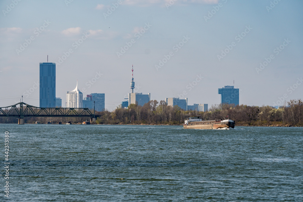 Skyline Wien mit Lastenboot vom Donau Ufer aus