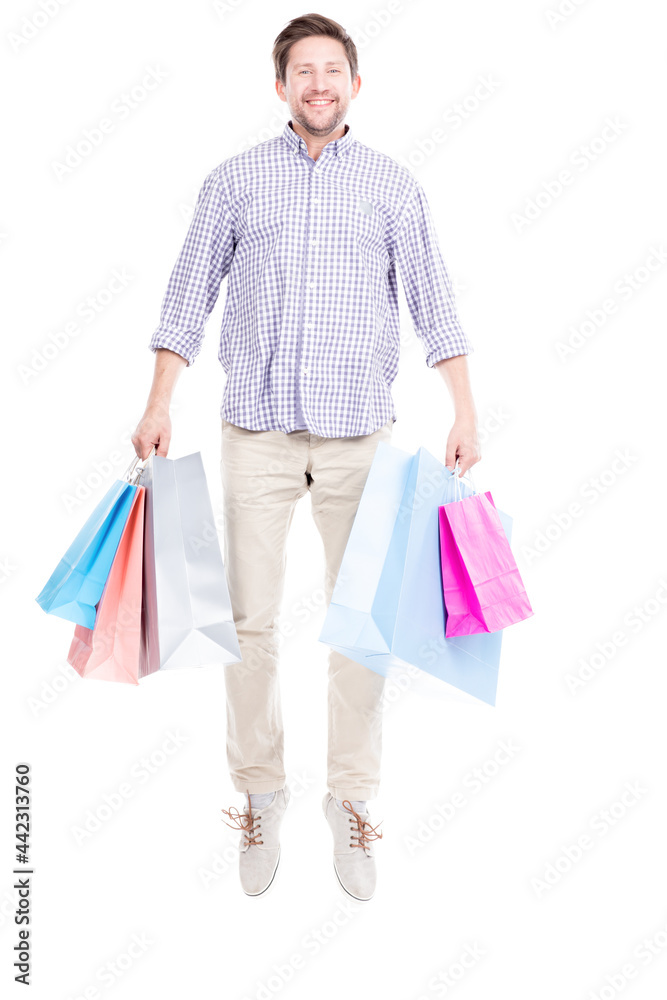 Studio portrait shot of young adult Caucasian man wearing casual clothes standing alone holding shopping bags, white background Studio portrait shot of young adult Caucasian man wearing casual clothes standing alone holding shopping bags, white background