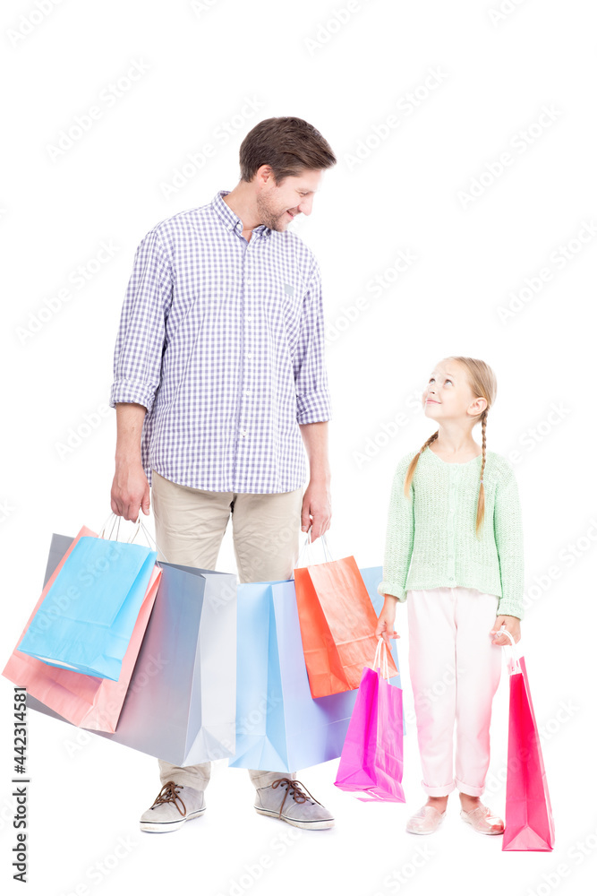 Studio portrait shot of happy young adult man spending time with his cute daughter doing shopping, white background Studio portrait shot of happy young adult man spending time with his cute daughter doing shopping, white background