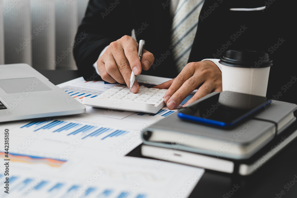 businessman or accountant hand holding pen working on calculator and laptop computer to calculate business data during make note at notepad, accountancy document at office businessman or accountant hand holding pen working on calculator and laptop computer to calculate business data during make note at notepad, accountancy document at office