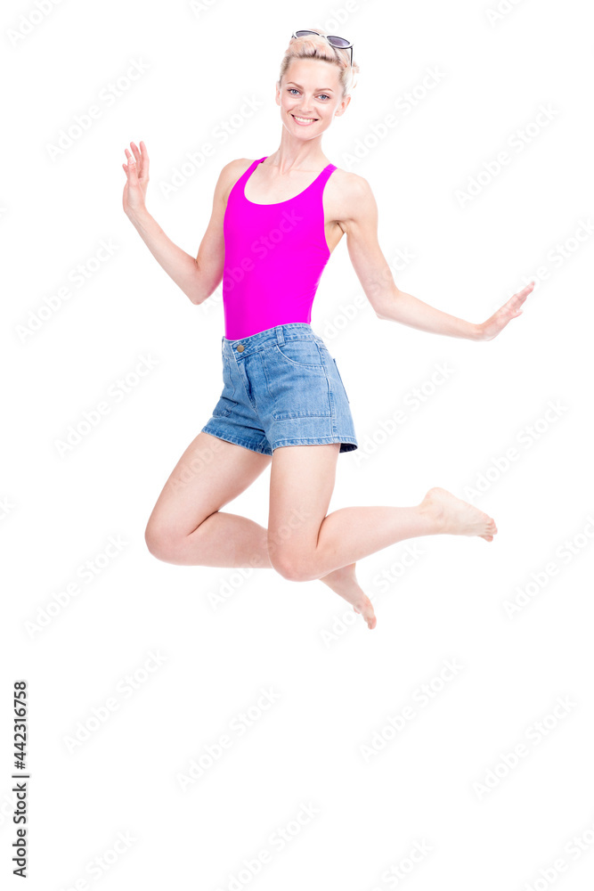 Vertical full length studio portrait of cheerful young Caucasian woman wearing summer outfit jumping, white background Vertical full length studio portrait of cheerful young Caucasian woman wearing summer outfit jumping, white background