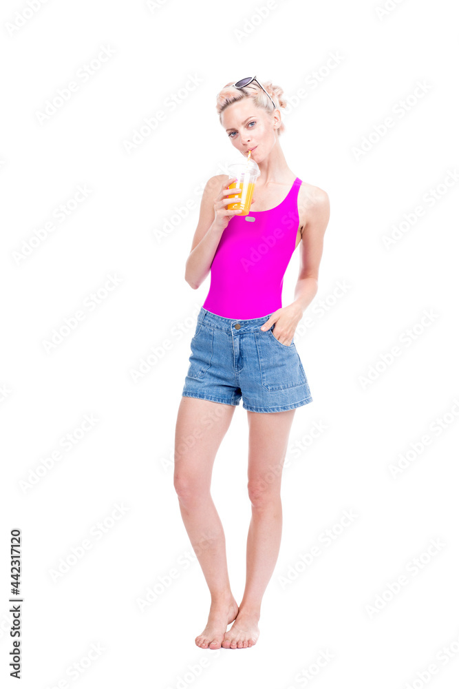 Vertical full length studio portrait of modern young Caucasian woman wearing summer outfit drinking fresh orange juice, white background Vertical full length studio portrait of modern young Caucasian woman wearing summer outfit drinking fresh orange juice, white background